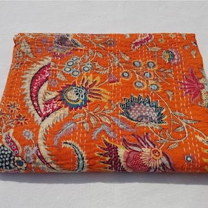 May include: Orange kantha quilt with a floral pattern. The quilt is made of cotton and has a hand-stitched design.