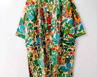 Könnte beinhalten: Eine lange, cremefarbene Robe mit einem Blumendruck mit bunten Blumen, Blättern und Figuren. Die Robe hat einen weißen Saum und einen Bindeverschluss.