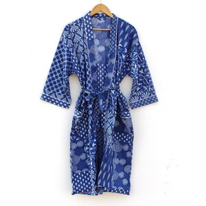 May include: A blue and white patterned cotton robe with a tie belt. The robe has a geometric and floral design.
