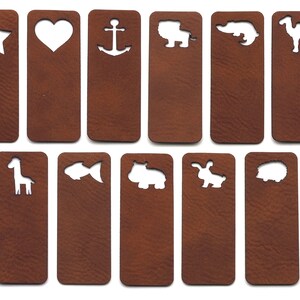 Puede incluir: Conjunto de 12 marcapáginas de cuero marrón con varios diseños recortados, que incluyen una estrella, un corazón, un ancla, un león, un caimán, un camello, una jirafa, un pez, un hipopótamo, un conejo y un erizo.