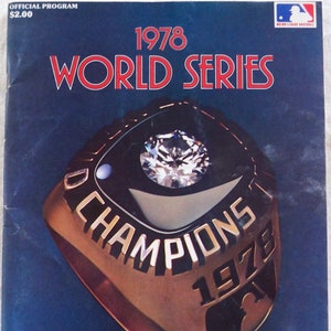 May include: A blue and gold 1978 World Series program with a large image of a championship ring. The ring is gold with a large diamond in the center and the words "Champions 1978" inscribed on the band. The program is for the 75th Anniversary Edition.