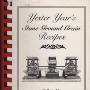 May include: A vintage cookbook titled "Yester Year's Stone Ground Grain Recipes" with a red and white spiral binding. The cover features a black and white illustration of three antique stone mills.