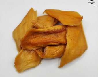 May include: A pile of dried mango slices, a popular snack food, with a golden brown color and a slightly translucent appearance.