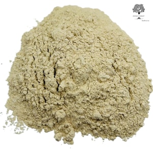 May include: A close-up of a pile of light beige powder. The powder is finely ground and has a slightly grainy texture.