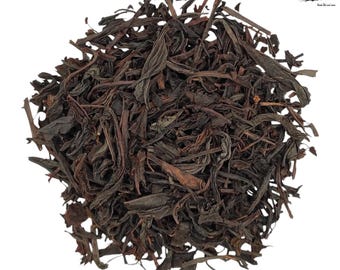 May include: Loose leaf black tea, dried and ready to brew. The tea leaves are dark brown and have a slightly reddish hue.