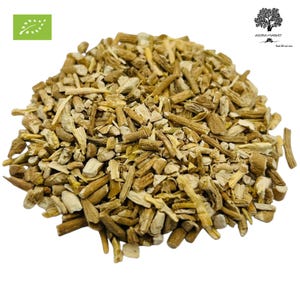 May include: A pile of dried, light brown herbal pieces, possibly roots or stems, fills the frame. The pieces vary in size and shape, with some appearing like small sticks. A green and white organic certification logo is in the upper left corner.