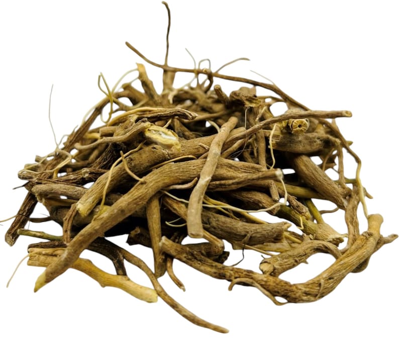 May include: A pile of dried, light brown valerian root pieces. The roots vary in size and shape, with some having a more fibrous appearance. The background is plain white, highlighting the natural color and texture of the roots.