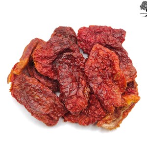 May include: A pile of sun-dried tomatoes, a popular ingredient in Mediterranean cuisine. The tomatoes are a deep red colour and have a wrinkled texture.