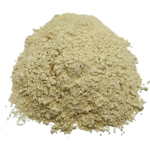 May include: A close-up of a pile of light beige powder. The powder is finely ground and has a slightly grainy texture.