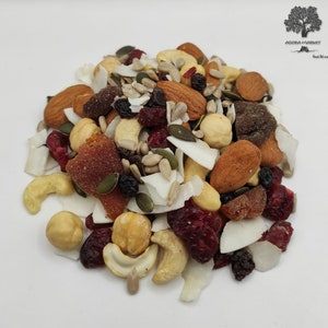 Könnte beinhalten: Eine Mischung aus Trockenfrüchten, Nüssen und Samen. Die Mischung enthält Cranberries, Mandeln, Cashews, Haselnüsse, Kürbiskerne, Sonnenblumenkerne und Kokosflocken.