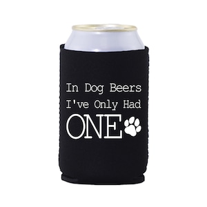 May include: Black neoprene can cooler with white text that reads "In Dog Beers I've Only Had ONE" with a paw print.
