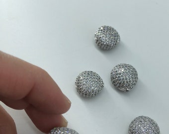 May include: Five silver-toned round beads with a clear crystal-like finish. The beads are all the same size and shape, and they are arranged in a cluster on a white surface.