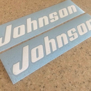 May include: Two white vinyl decals with the word "Johnson" in a bold, stylized font on a light blue background.