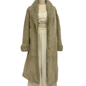 May include: A long, brown corduroy coat with a faux fur collar and cuffs. The coat is on a white mannequin.