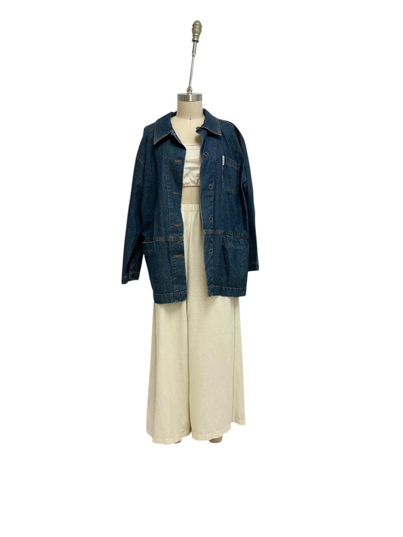 May include: A dark blue denim jacket with a button-up front and a light beige pair of wide-leg pants.