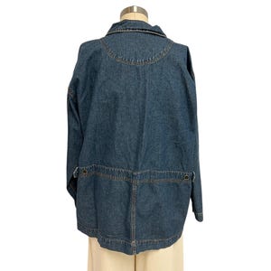 May include: A blue denim jacket with a button-up front and long sleeves. The jacket has a collar and two pockets on the front.