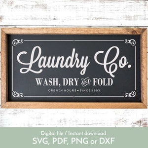 May include: A black and white sign with a wooden frame that reads "Laundry Co. Wash, Dry and Fold Open 24 Hours. Since 1993".