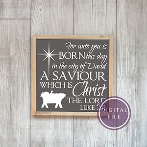 May include: A grey wooden sign with white text that reads "For unto you is BORN this day in the city of David A SAVIOUR WHICH IS Christ THE LORD LUKE 2". The sign has a star and a manger with a baby inside.