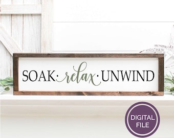 Puede incluir: Un letrero de madera con el texto "SOAK: relax: UNWIND" en letras negras y verdes. El letrero está enmarcado en un marco de madera marrón oscuro.