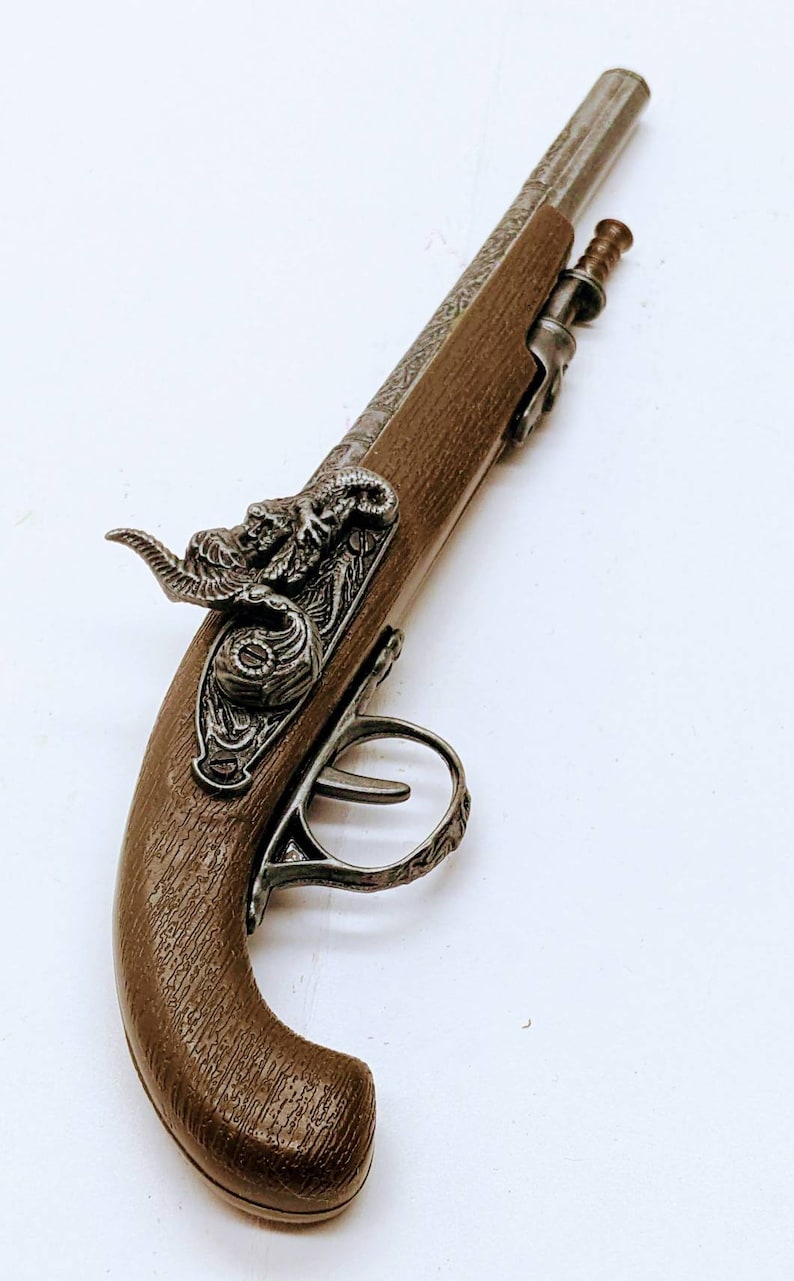 May include: A brown and silver toy pistol with a decorative design on the handle and a detailed animal head on the top.