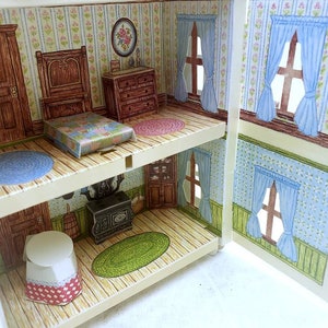 Puede incluir: Una casa de mu&ntilde;ecas en miniatura de dos pisos, con un dormitorio que incluye una cama, una c&oacute;moda y una alfombra azul. El piso inferior tiene una cocina con una estufa y un piso de cuadros rojos y blancos.