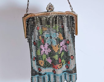 May include: A vintage silver mesh purse with a floral design in shades of pink, blue, green, orange, and red. The purse has a chain strap and a clasp closure.