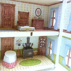 Puede incluir: Una casa de mu&ntilde;ecas en miniatura con dos habitaciones, una con una estufa de le&ntilde;a y un fregadero de cocina, y la otra con una cama y una c&oacute;moda. La casa de mu&ntilde;ecas tiene papel tapiz azul y blanco con motivos florales.