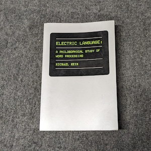 May include: A white book cover with a black rectangle containing the text "ELECTRIC LANGUAGE: A PHILOSOPHICAL STUDY OF WORD PROCESSING MICHAEL HEIM" in yellow text.