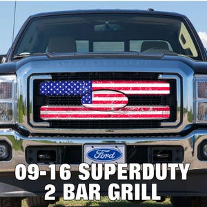 May include: A black Ford Super Duty truck with a chrome grill featuring an American flag design. The grill is a 2-bar style and the text "09-16 SUPERDUTY 2 BAR GRILL" is displayed at the bottom.