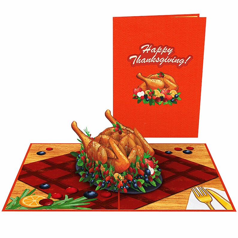 May include: A 3D pop-up card featuring a roasted turkey with a red and white checkered tablecloth and the words "Happy Thanksgiving!" on the front.