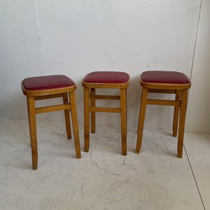 Set of 3 Romanian mid century wooden stools with red vinyl seats