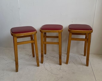 Set of 3 Romanian mid century wooden stools with red vinyl seats