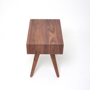 May include: A dark brown wooden end table with a rectangular top and four angled legs.