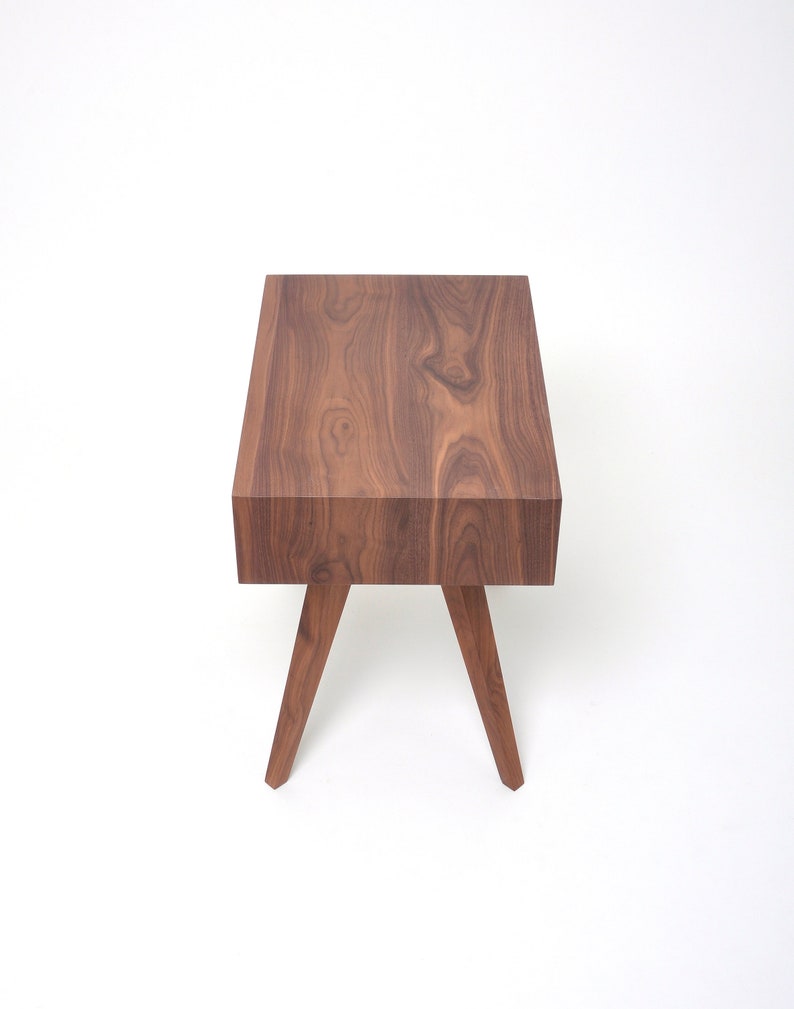 May include: A dark brown wooden end table with a rectangular top and four angled legs.