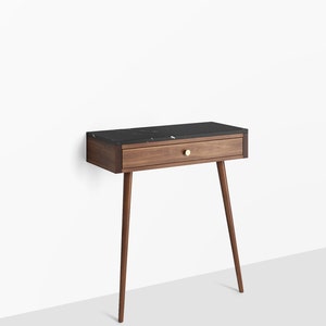 Peut inclure: Une console en bois de noyer avec un plateau en marbre noir et un tiroir. La console a quatre pieds effilés et une poignée en laiton sur le tiroir.