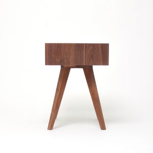 May include: A dark brown wooden side table with a square top and four angled legs.