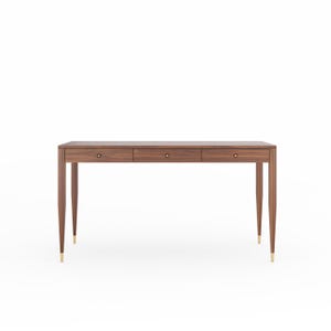 May include: A rectangular wooden desk featuring a dark brown wood grain finish, three horizontal drawers with small circular knobs, and four tapered legs that end in metallic gold-toned caps at the base of each leg.