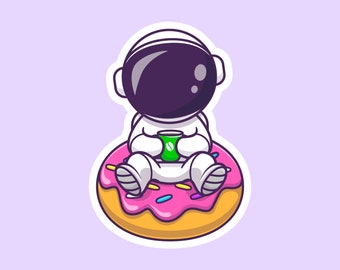 Puede incluir: Un astronauta de dibujos animados con un traje espacial blanco y un casco negro se sienta en una rosquilla rosa y amarilla con chispas de colores. El astronauta sostiene una taza de café verde.