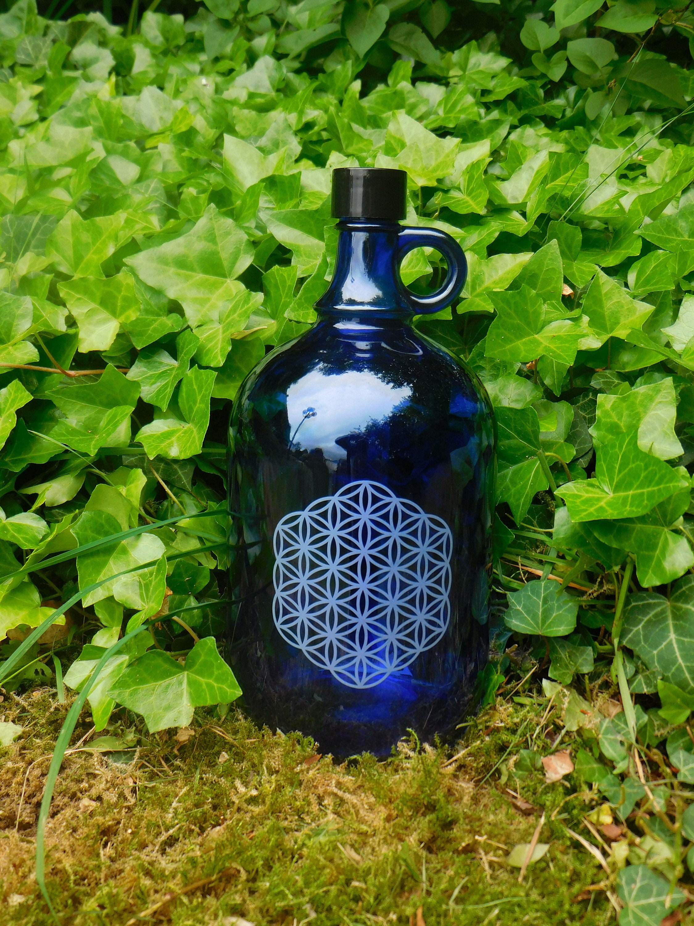 Botella de cristal azul de 2 litros con asa con flor de la vida