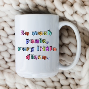 May include: White ceramic mug with a colorful text design that reads "So much panic, very little disco."