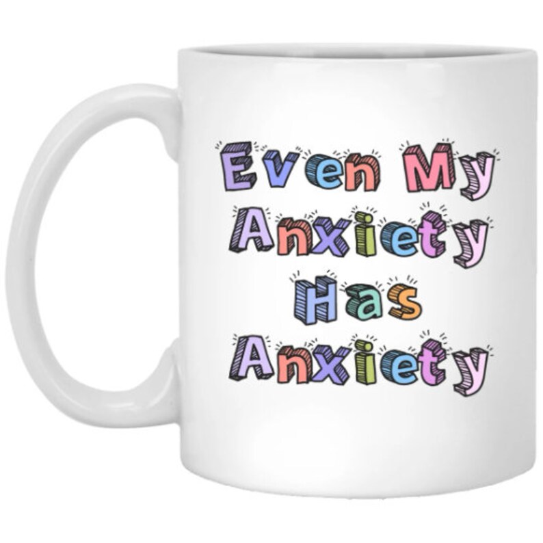 May include: White ceramic mug with a colorful design that says "Even My Anxiety Has Anxiety".