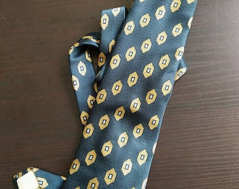 May include: A dark blue necktie with a pattern of gold and white diamonds.