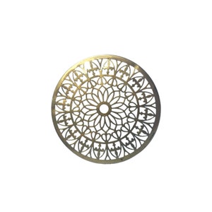 Op de afbeelding: Een cirkelvormig, goudkleurig metalen decoratief stuk met een ingewikkeld, opengewerkt bloemenontwerp. Het ontwerp heeft een centrale cirkel met uitstralende patronen en een reeks herhalende bloemen- en bladmotieven. Het stuk is waarschijnlijk een decoratief element.