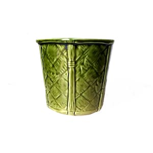 May include: A green ceramic planter with a woven basket design. The planter has a cylindrical shape with a slightly flared top. Vertical bamboo-like accents run down the sides. The planter is approximately 6 inches tall.