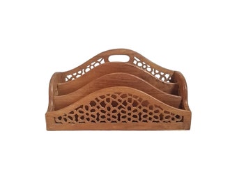 May include: A wooden desk organizer with a natural finish. The organizer has three sections and a handle. The front features a decorative, openwork design. The overall design is a warm, medium brown color.