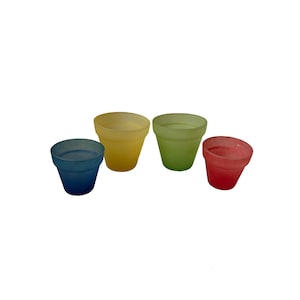 Peut inclure: Quatre petits pots de fleurs en verre colorés, bleus, jaunes, verts et rouges. Les pots sont disposés en rangée, chacun ayant une forme et une taille légèrement différentes. Le verre a un aspect givré.