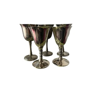 May include: A set of five silver-colored goblets. Each goblet has a flared rim, a slender stem, and a decorative, twisted design on the lower portion of the stem. The goblets are arranged on a white background.