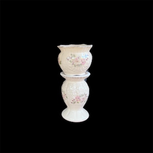 May include: A two-piece ceramic vessel set featuring a cream-coloured base with an embossed scrollwork texture. Both pieces are decorated with a floral pattern of pink and purple flowers with green leaves and finished with a thin gold-toned rim.
