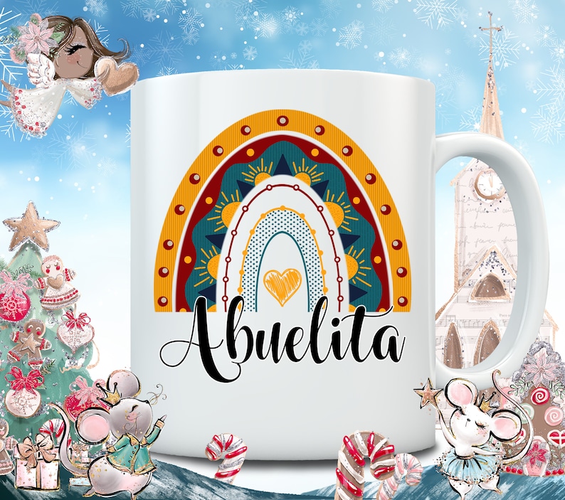 May include: White ceramic mug featuring a colorful rainbow design with a heart and the word "Abuelita" in black script. The rainbow includes shades of yellow, teal, and red. The mug has a standard handle and is likely for hot beverages.