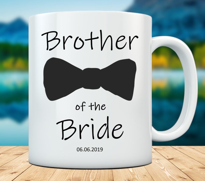Pu&ograve; includere: Tazza in ceramica bianca con un papillon nero e la scritta "Brother of the Bride" in nero. La data "06.06.2019" &egrave; stampata sotto. La tazza ha un manico bianco.